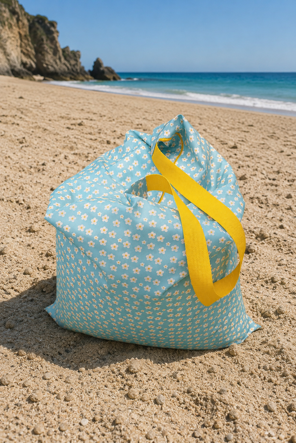 Puff de praia Daisy Pop Sunshine azul com margaridas e fita amarela na areia